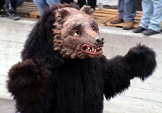 Fasnacht in Thaur: zottelige Bärenfigur mit geschnitzter Maske