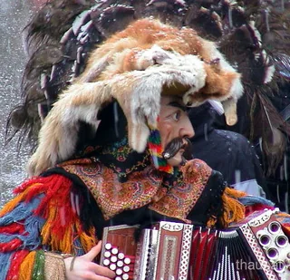 Fasnacht in Thaur: maskierte Figur mit Ziehharmonika
